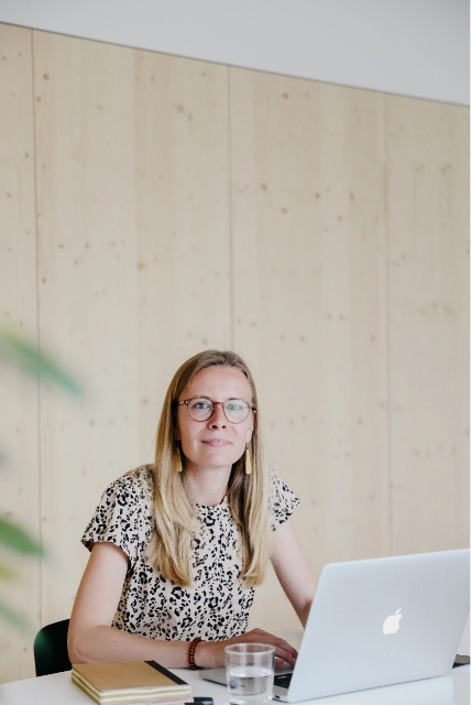 Content creator, communicatiemedewerker en copywriter voor kinderopvang, Sveva, zit achter haar laptop aan haar bureau.